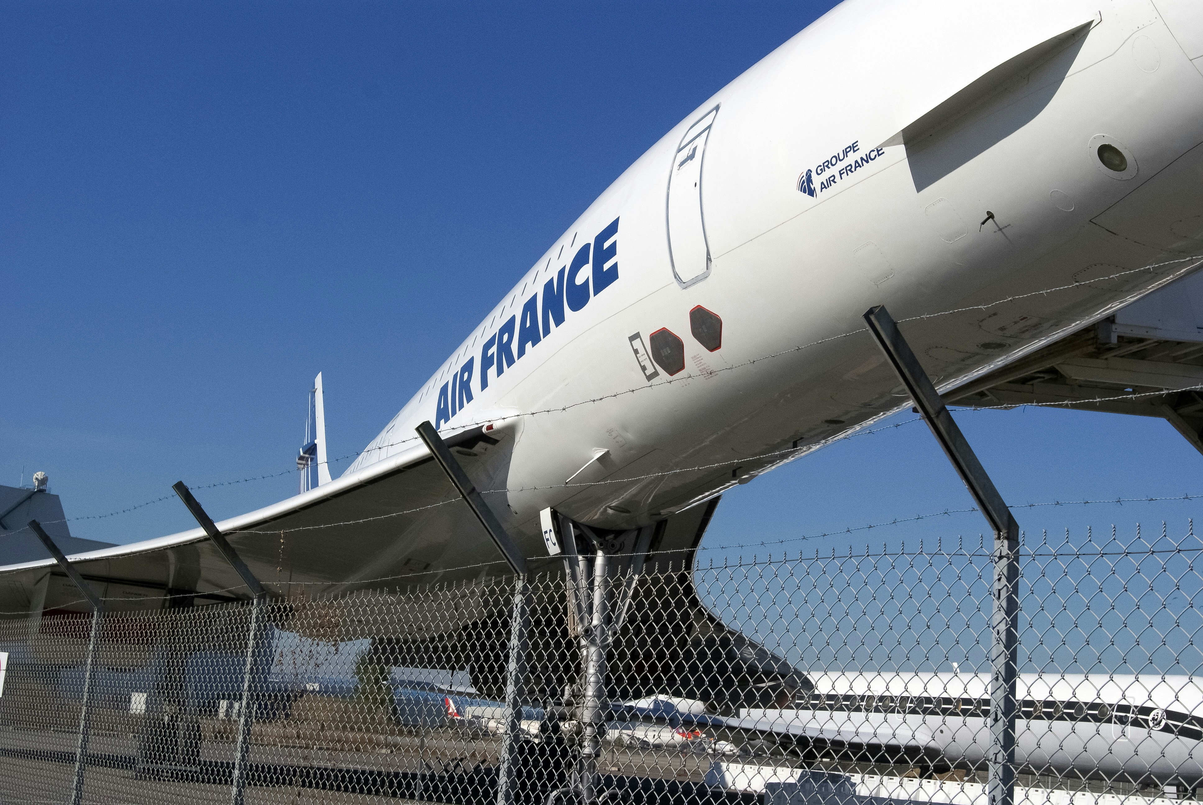 white airplane on gray metal fence during daytime